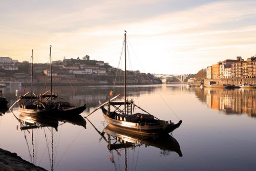 Blick auf die historische Altstadt von Porto mit bunten Häusern am Fluss Douro, im Hintergrund die ikonische Brücke Dom Luís I.